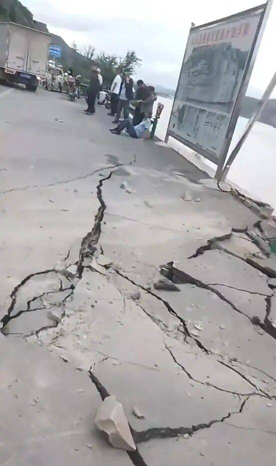 山西临县一公路落石砸中过往车辆，有人被困严重变形的车内，路面出现明显开裂